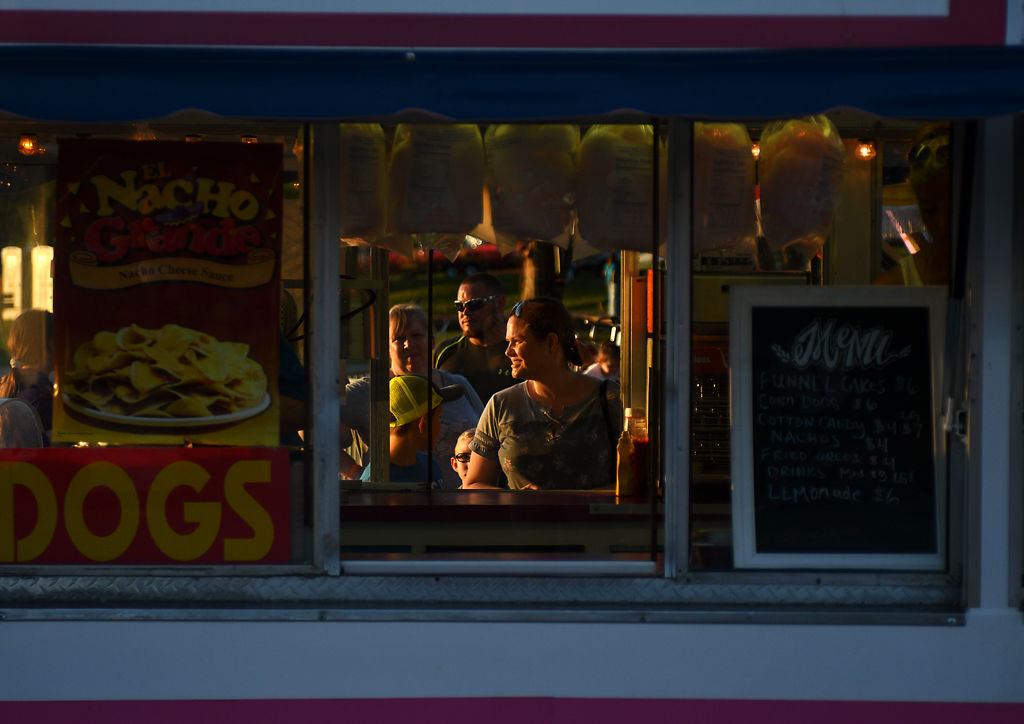 Customers line up to get some treats at a funnel cake and fresh-squeezed lemonade stand